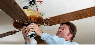 Electrician installing ceiling fan